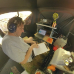 Operator with headphones logging contacts inside a Field Day portable tent station